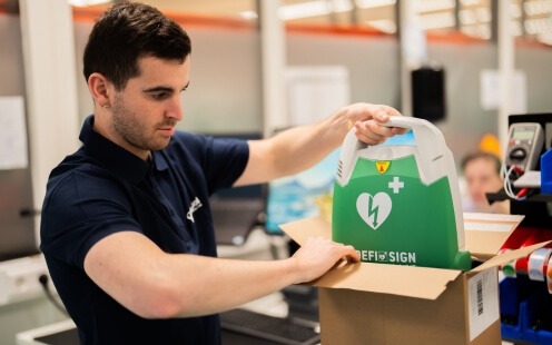 Een DefiSign AED wordt in een doos gestopt voor retour na een controle in het Medisol Service Center.